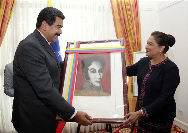 O presidente da Venezuela Nicolas Maduro e a primeira-ministra de Trinidad and Tobago, Kamla Persad-Bissessar, trocam um quadro de Simon Bolívar, o herói da revolução sul-americana.